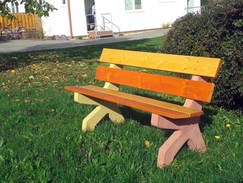 Barevná betonová lavička u školky v Libranticích.